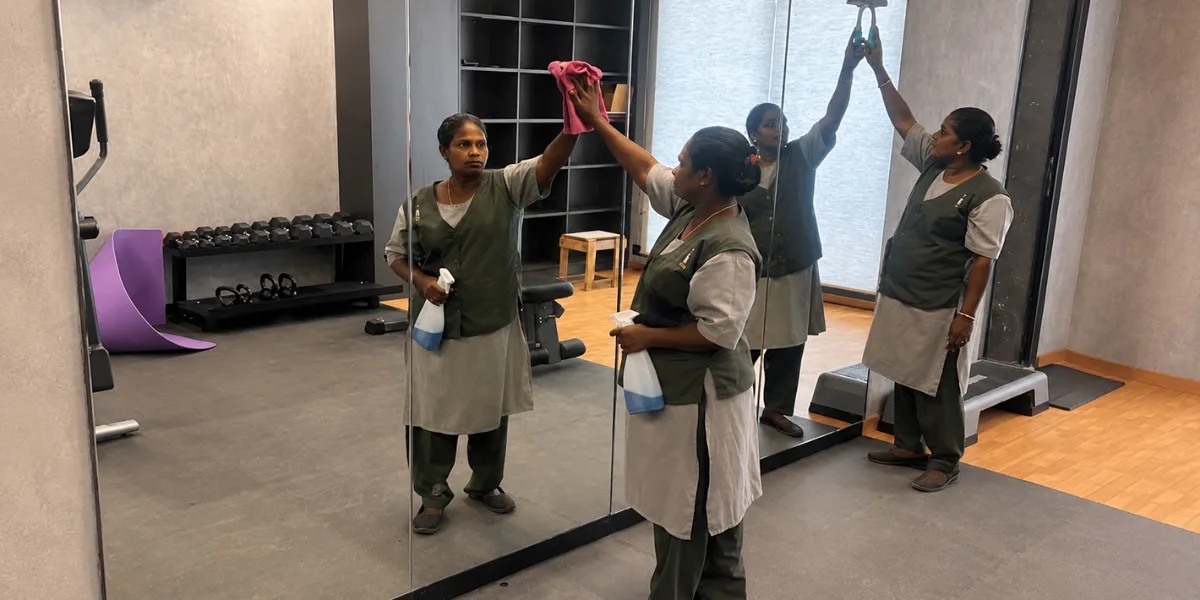 GlitzUp housekeeping staff cleaning mirrors in a gym